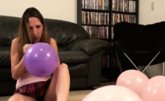 Good looking brunette blowing balloons