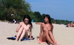 Nude beach girl sunbathes next to her man outdoors